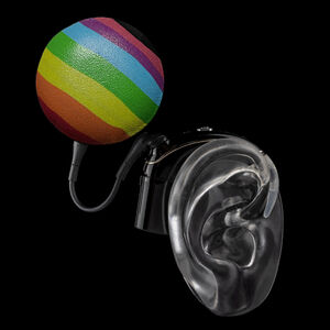 Black ear mould shows cover for cochlear implant in horizontal rainbow stripes